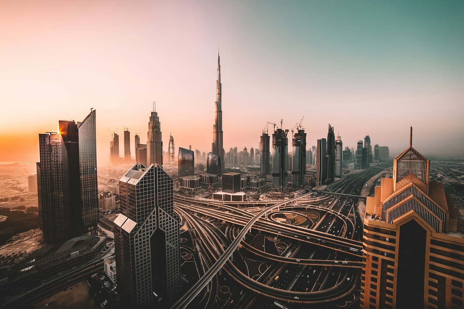 The Burj Khalifa rising over Dubai's downtown skyline and the Sheikh Zayed Road interchange at sunrise
