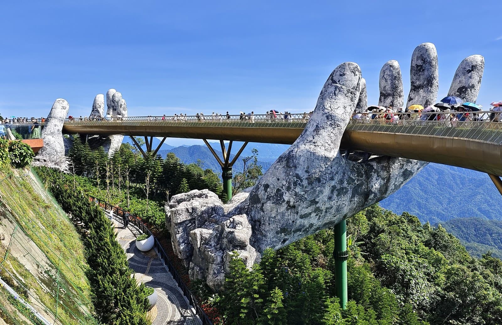 The Golden Bridge at Ba Na Hills, held up by two giant stone hands above forested mountains